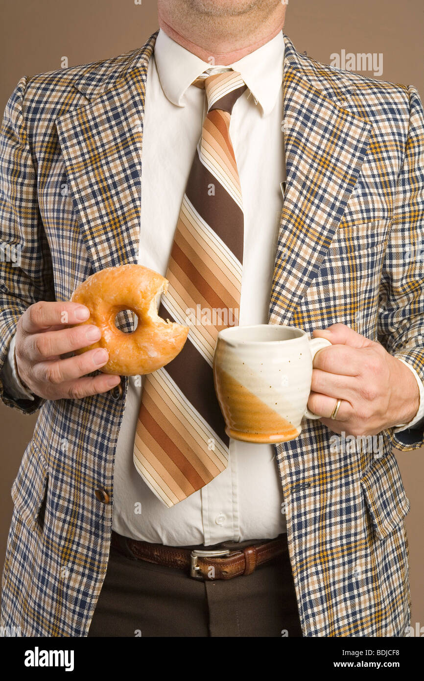 Imprenditore retrò mangiando una ciambella e bere una tazza di caffè Foto Stock