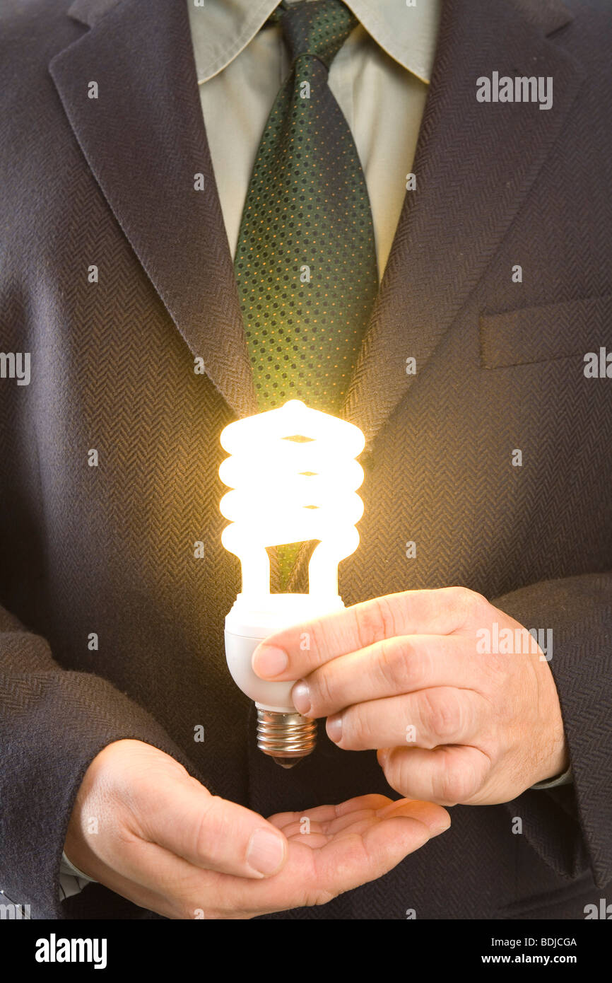 Imprenditore tenendo accesa lampadina a basso consumo Foto Stock
