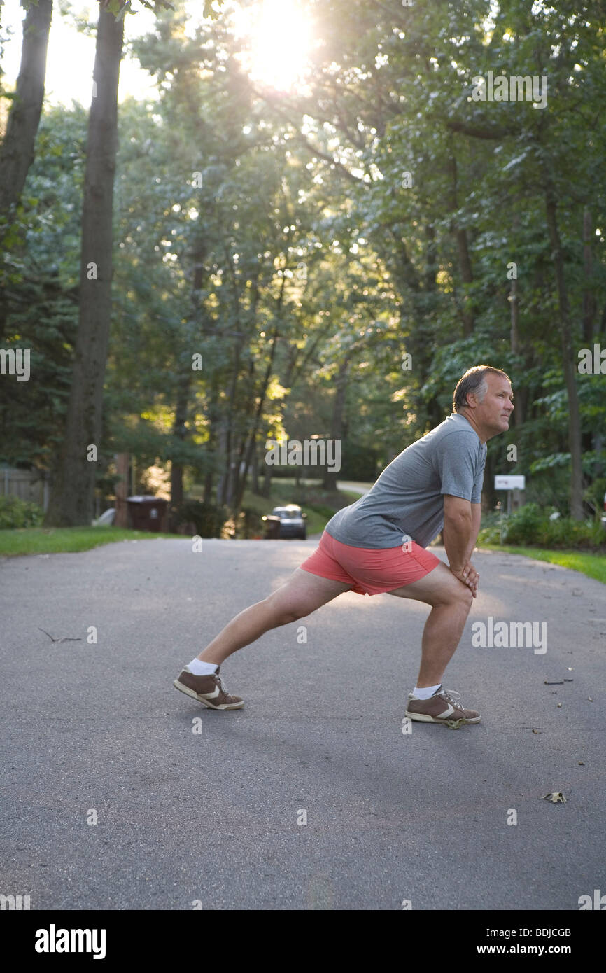 L'uomo stretching prima corsa mattutina Foto Stock