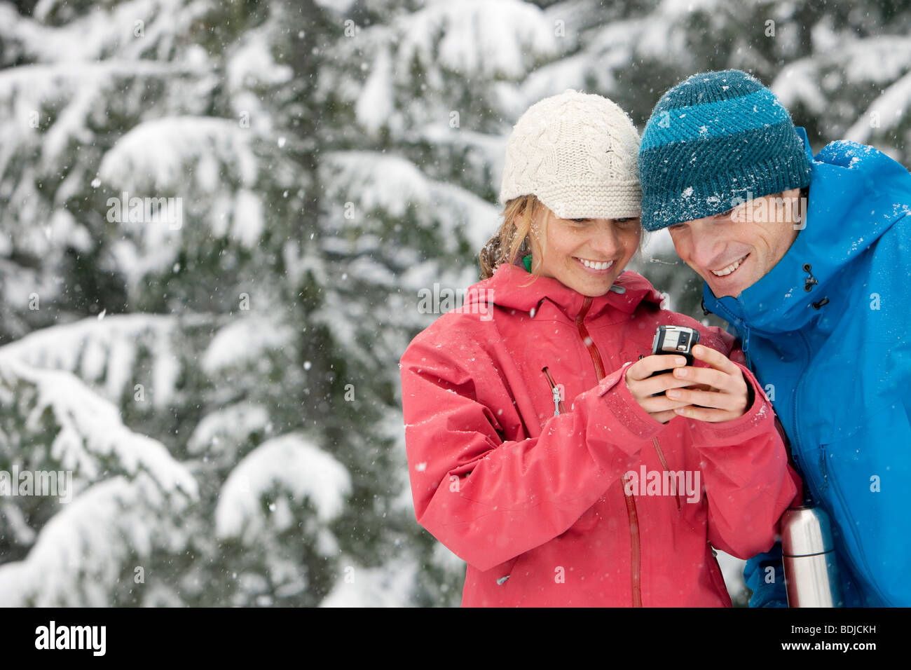Close-up del giovane di utilizzo di PDA in esterno e in inverno, Whistler, British Columbia, Canada Foto Stock