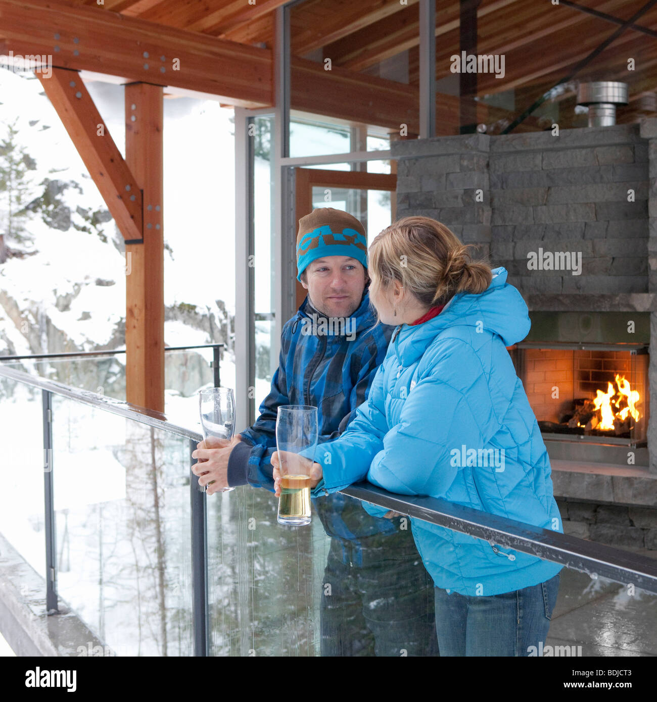 L uomo e la donna in piedi sul balcone Chalet, Whistler, British Columbia, Canada Foto Stock