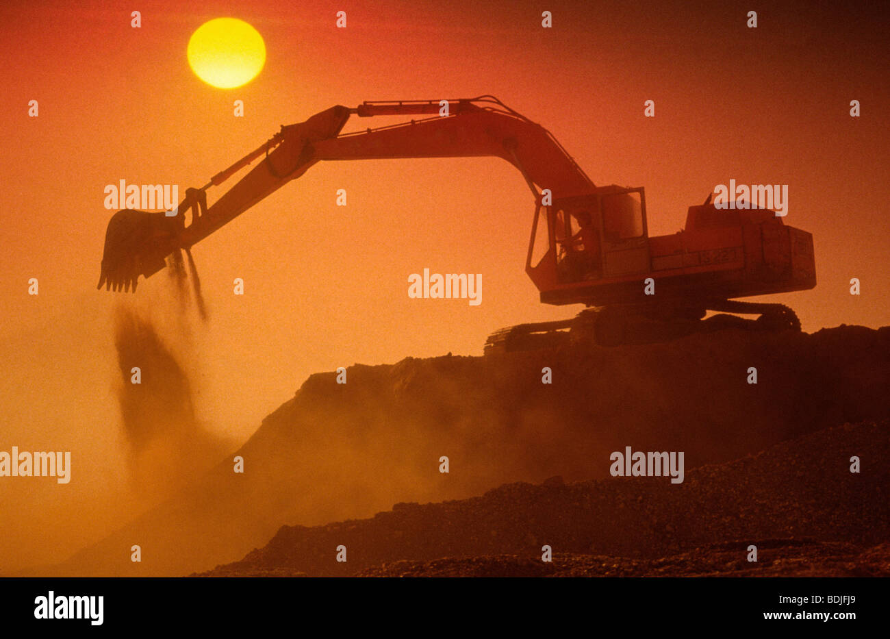 Per macchine movimento terra, Escavatore a lavoro, Silhouette al tramonto Foto Stock