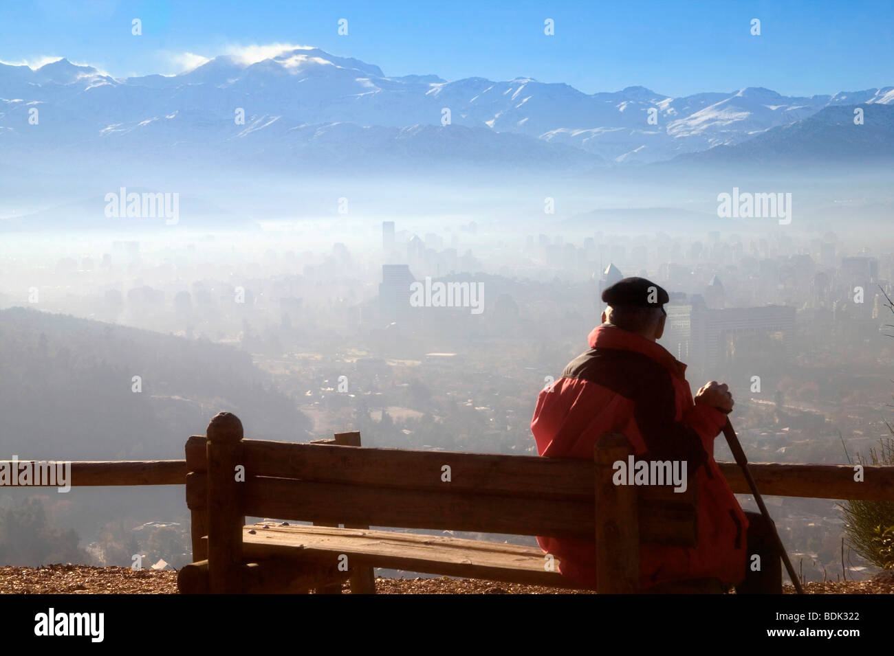 Uomo che indossa hat affacciato sul paesaggio di Santiago e con montagne delle Ande in early morning mist, Cile Foto Stock