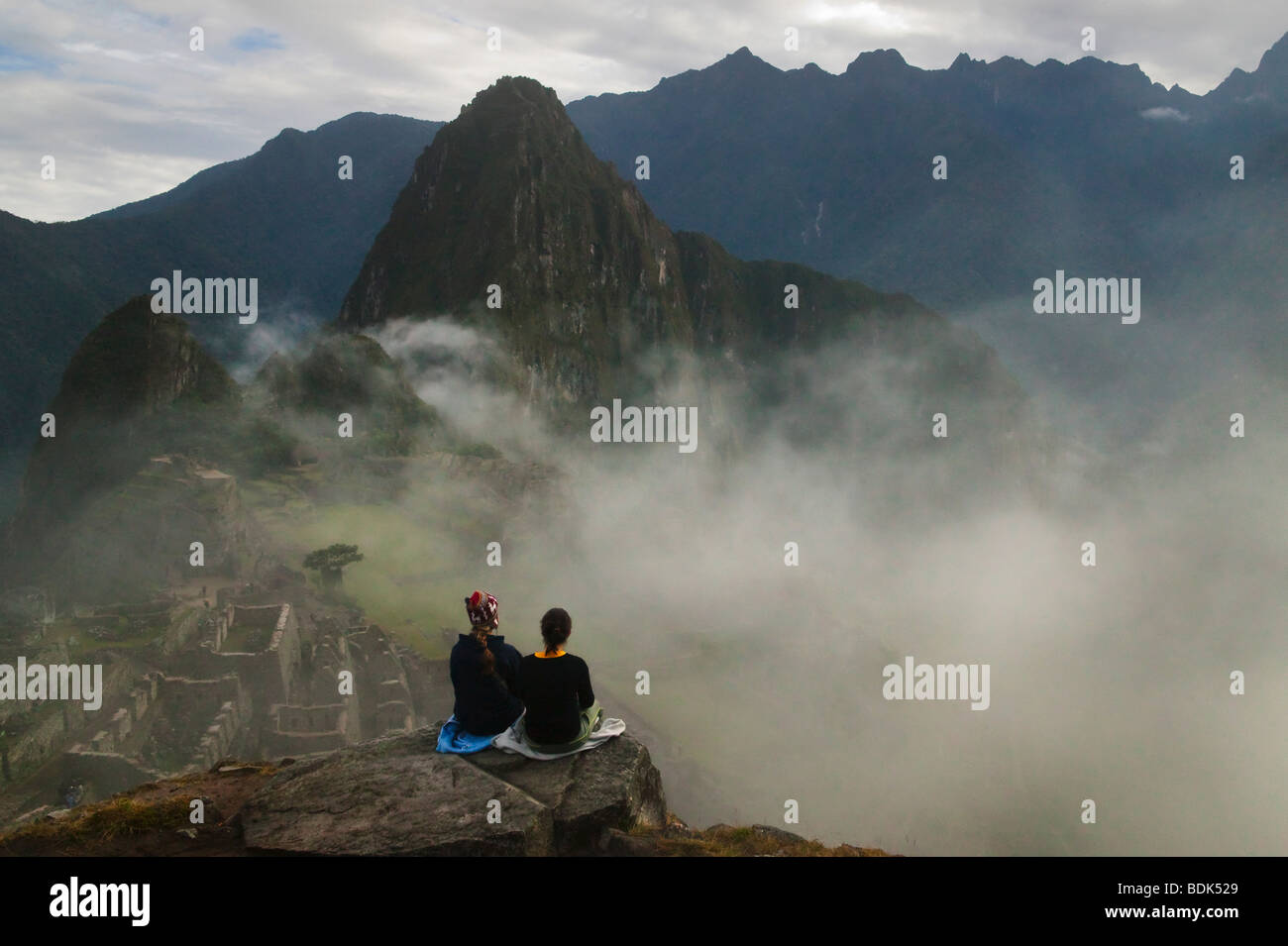 Turisti in antiche rovine di Machu Picchu in montagna Ande in early morning mist, Perù Foto Stock