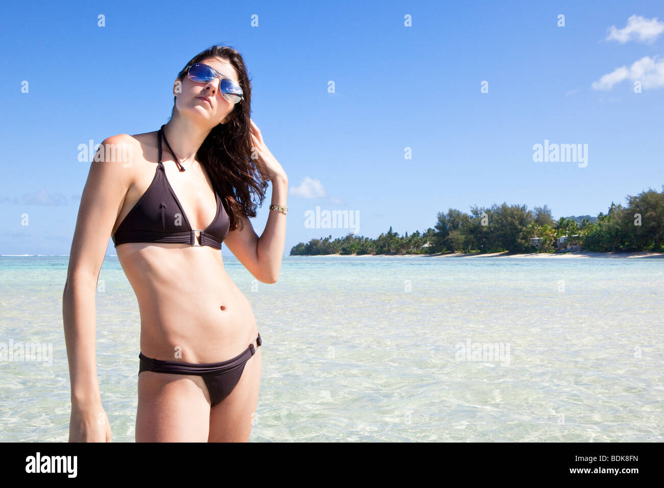 Modello in posa su una spiaggia deserta a Rarotonga nelle Isole Cook nel Pacifico del Sud Foto Stock