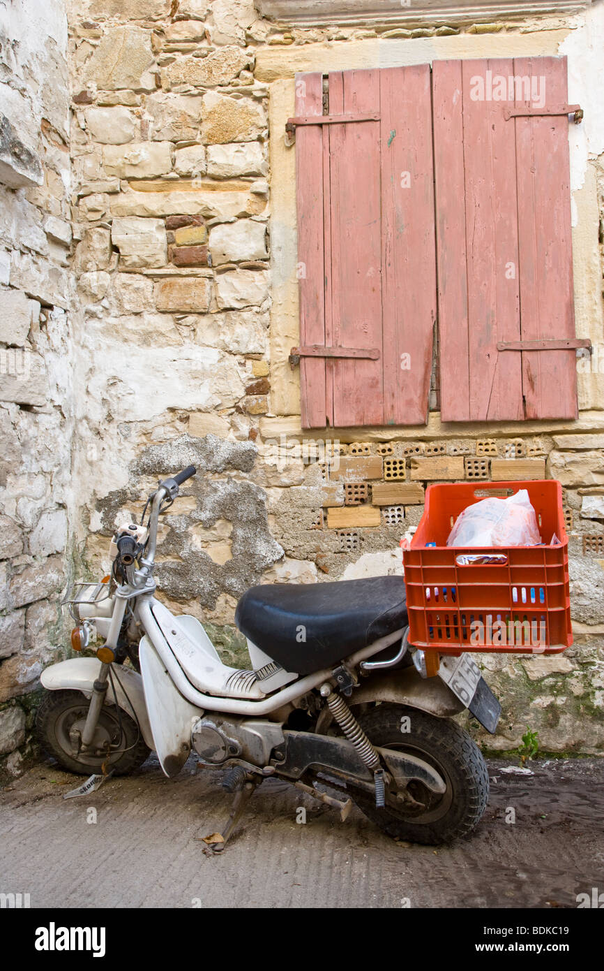 Un vecchio scooter parcheggiato in vicoli di Gaios, Paxos Mare Ionio, Grecia Foto Stock