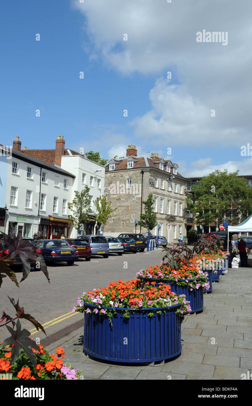 Fiore di vasche e di automobili parcheggiate in estate sole Piazza del Mercato Warwick Inghilterra Foto Stock