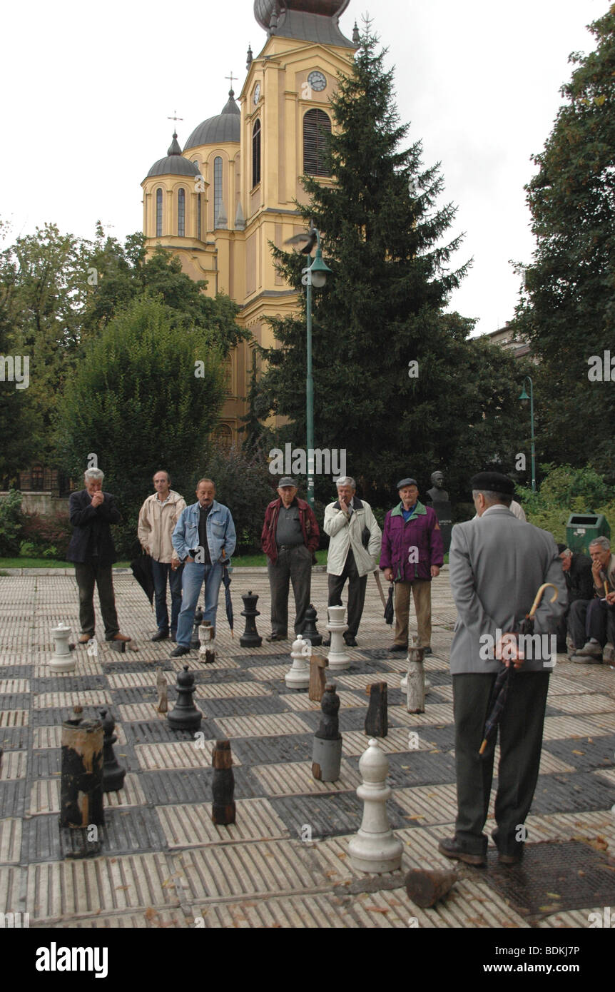 Un gruppo di uomini giocano su una vita dimensioni scheda di scacchi in una piazza della città nella città di Sarajevo, Bosnia ed Erzegovina. Foto Stock