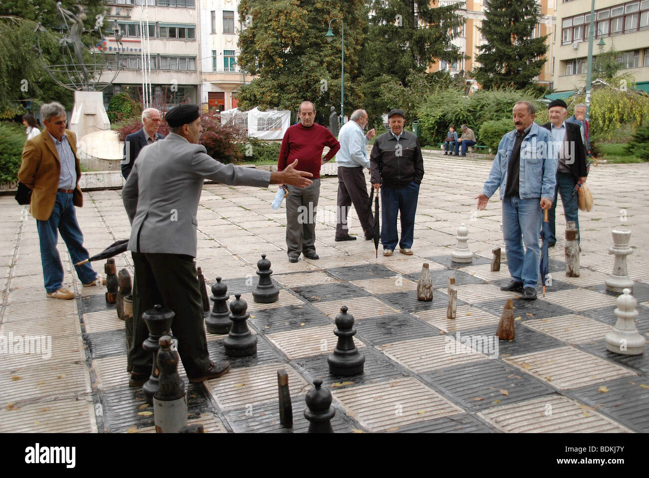 Un gruppo di uomini giocano su una vita dimensioni scheda di scacchi in una piazza della città nella città di Sarajevo, Bosnia ed Erzegovina. Foto Stock