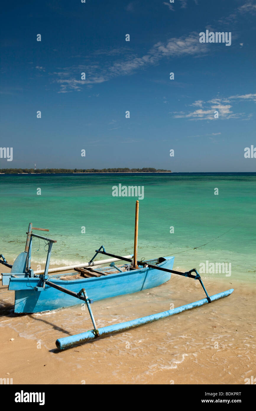 Indonesia, Lombok, Gili Air, dipinte di blu outrigger barca sulla splendida spiaggia di sabbia bianca Foto Stock