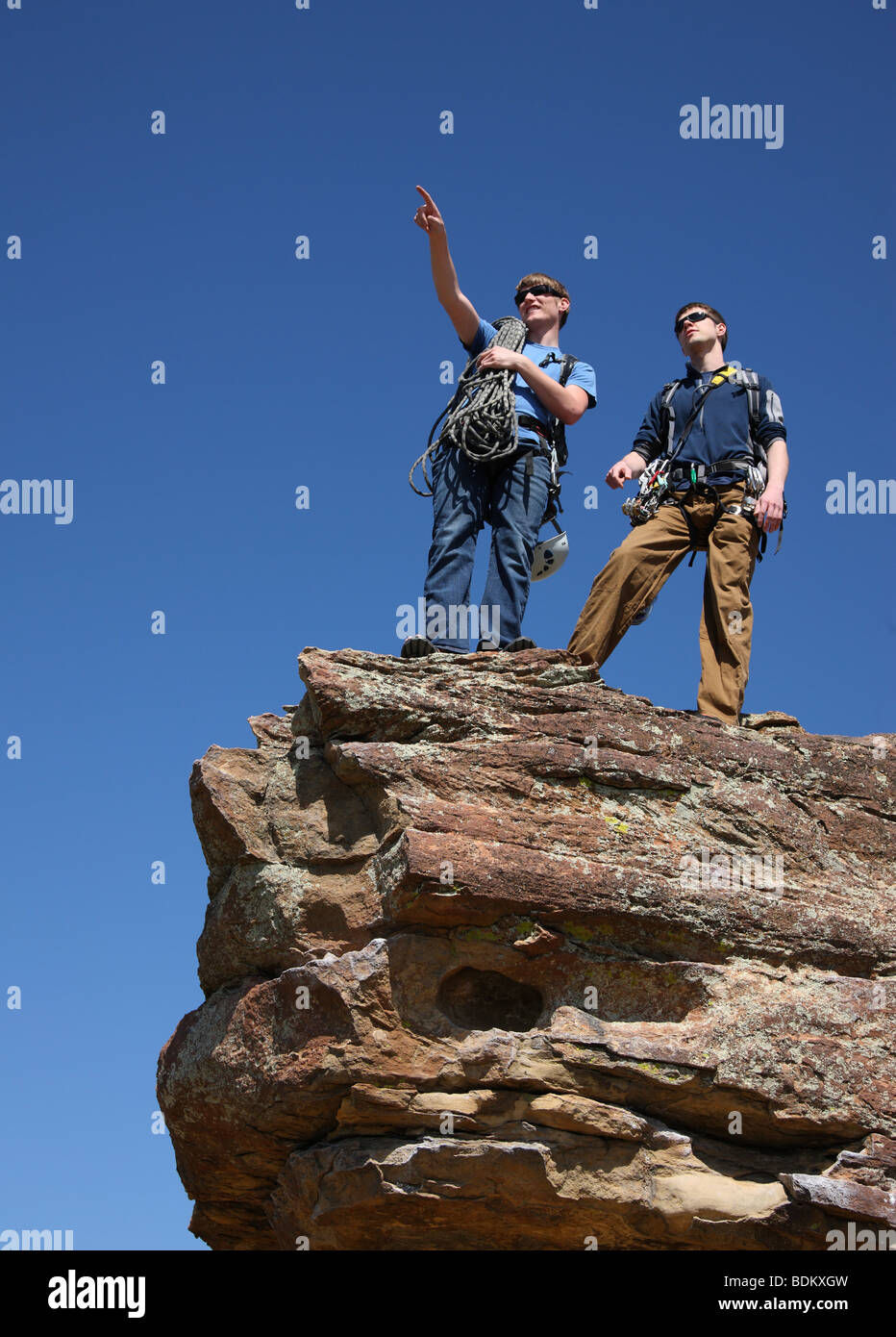 Due arrampicatori stand sul picco roccioso sottolineando Foto Stock