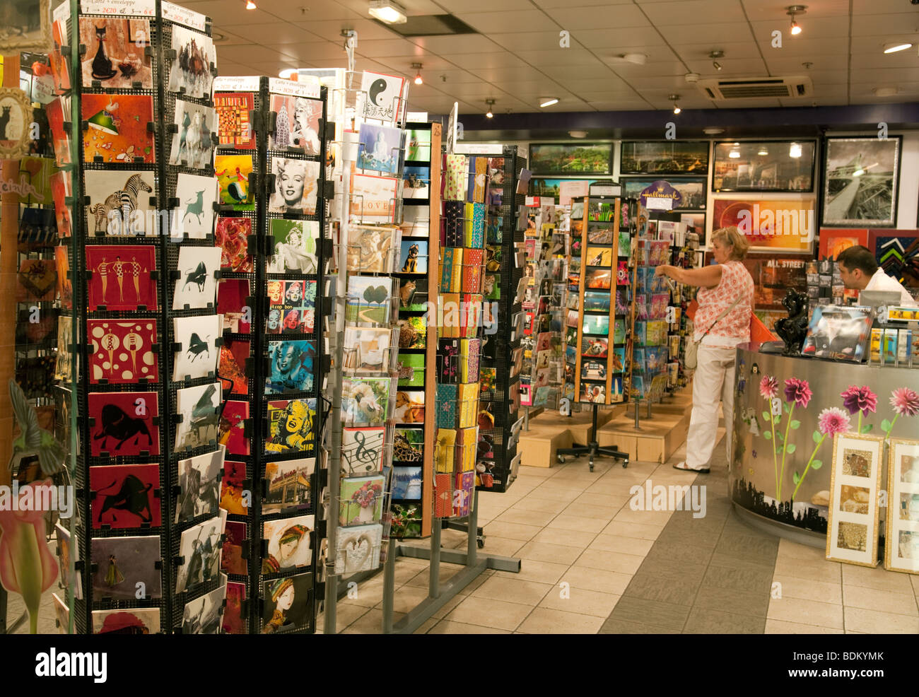 Un turista cartoline di acquisto in un negozio di Parigi Foto Stock
