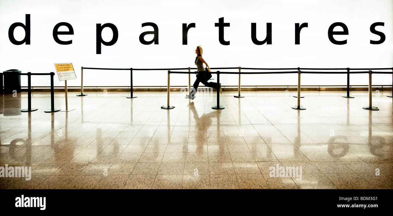 Colore Colore immagine panoramica di una ragazza che corre per la partenza lounge per catturare il suo volo Foto Stock