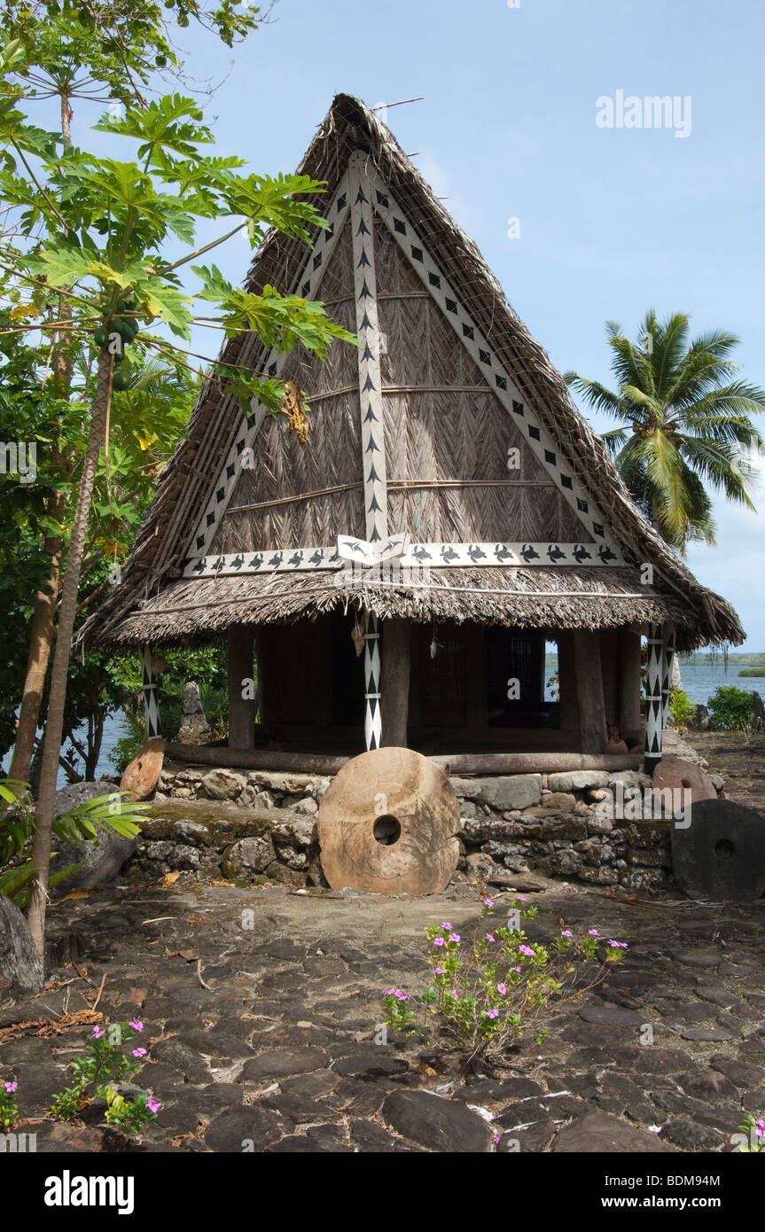 Un uomo casa sull'acqua con denaro in pietra sull'isola di Yap. Foto Stock