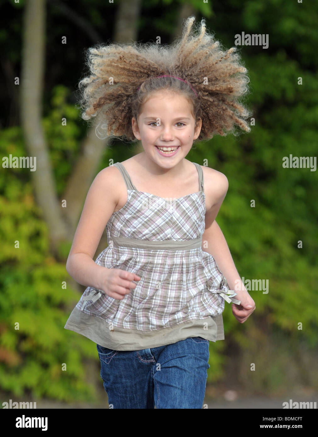 Un felice ragazza giovane con fantastici capelli crespi. Foto Stock