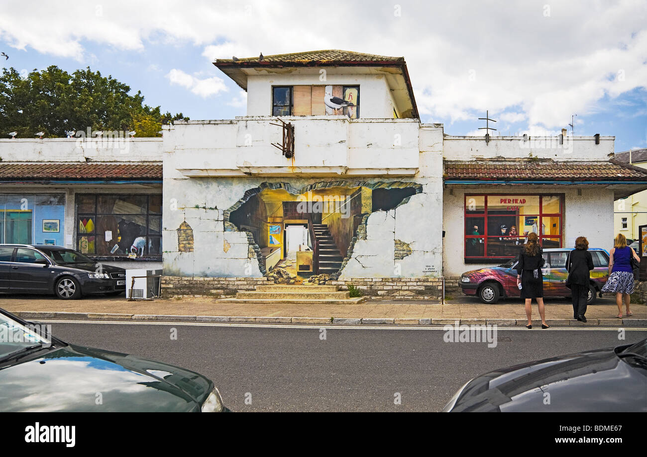 Trompe l'oeil effetto murales dipinti sul lato del molo fatiscente edificio di testa. Il lungomare, Swanage. Il Dorset. Regno Unito. Foto Stock