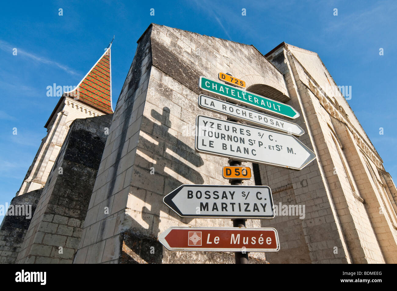 Più cartelli stradali di fronte Preuilly-sur-Claise chiesa abbaziale, Francia. Foto Stock