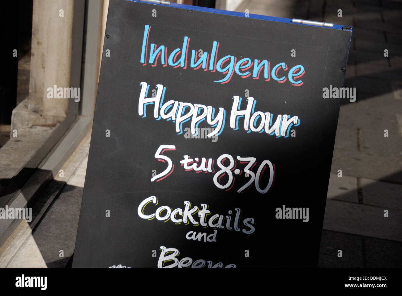 Indulgenza Happy Hour segno di promozione al di fuori dei bar, London, England, Regno Unito Foto Stock