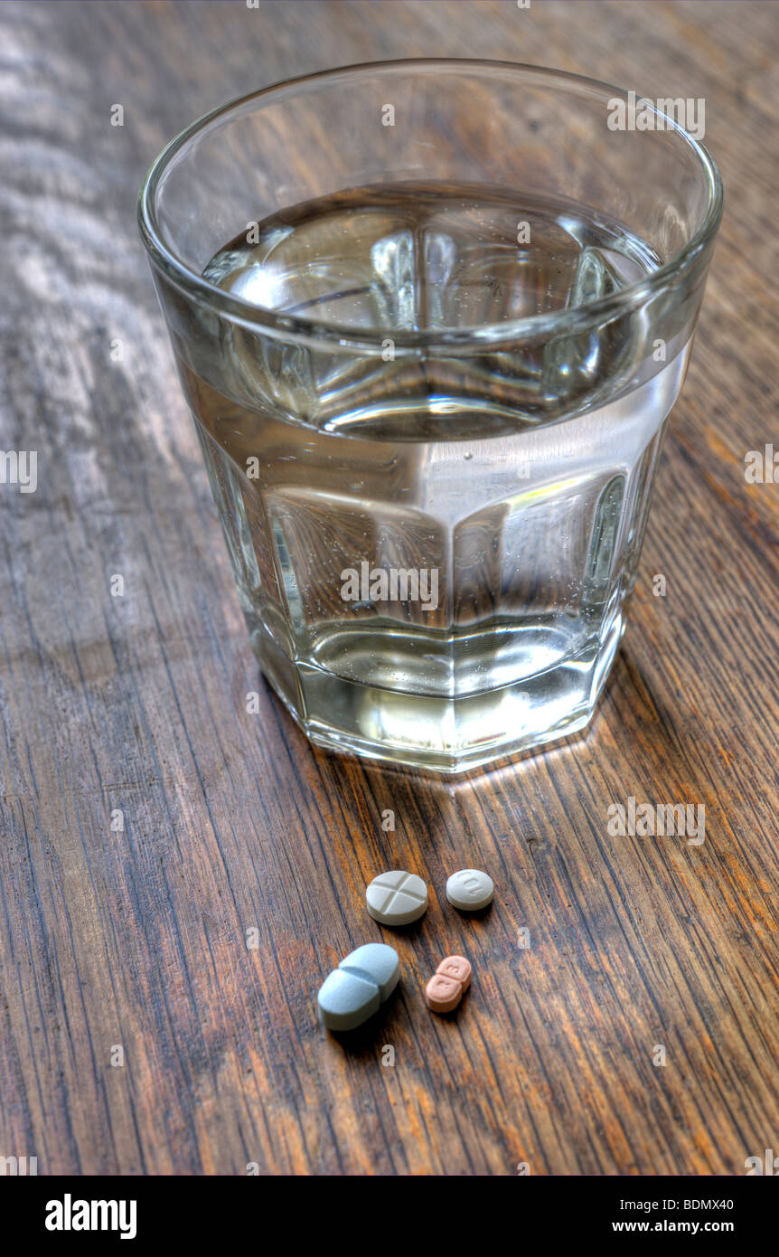 Bicchiere di acqua e pillole Foto Stock