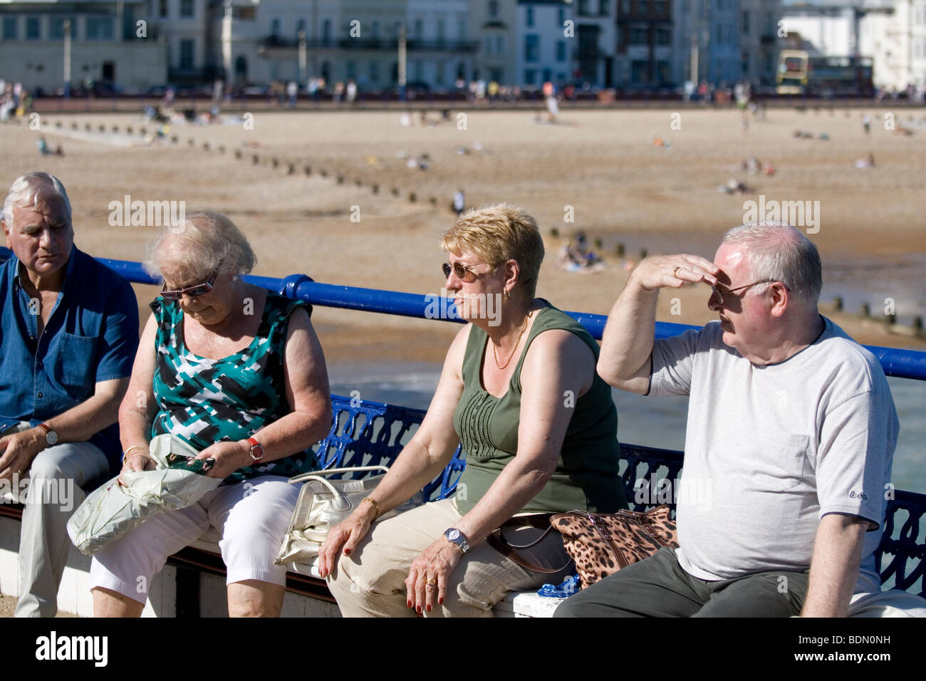 Le persone anziane siedono sul molo a Eastbourne, Inghilterra. Foto Stock