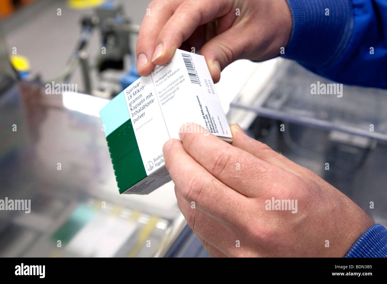 Dipendente di Boehringer Ingelheim GmbH controllo respiratorio di un farmaco da una macchina confezionatrice nella logistica e confezionamento cente Foto Stock