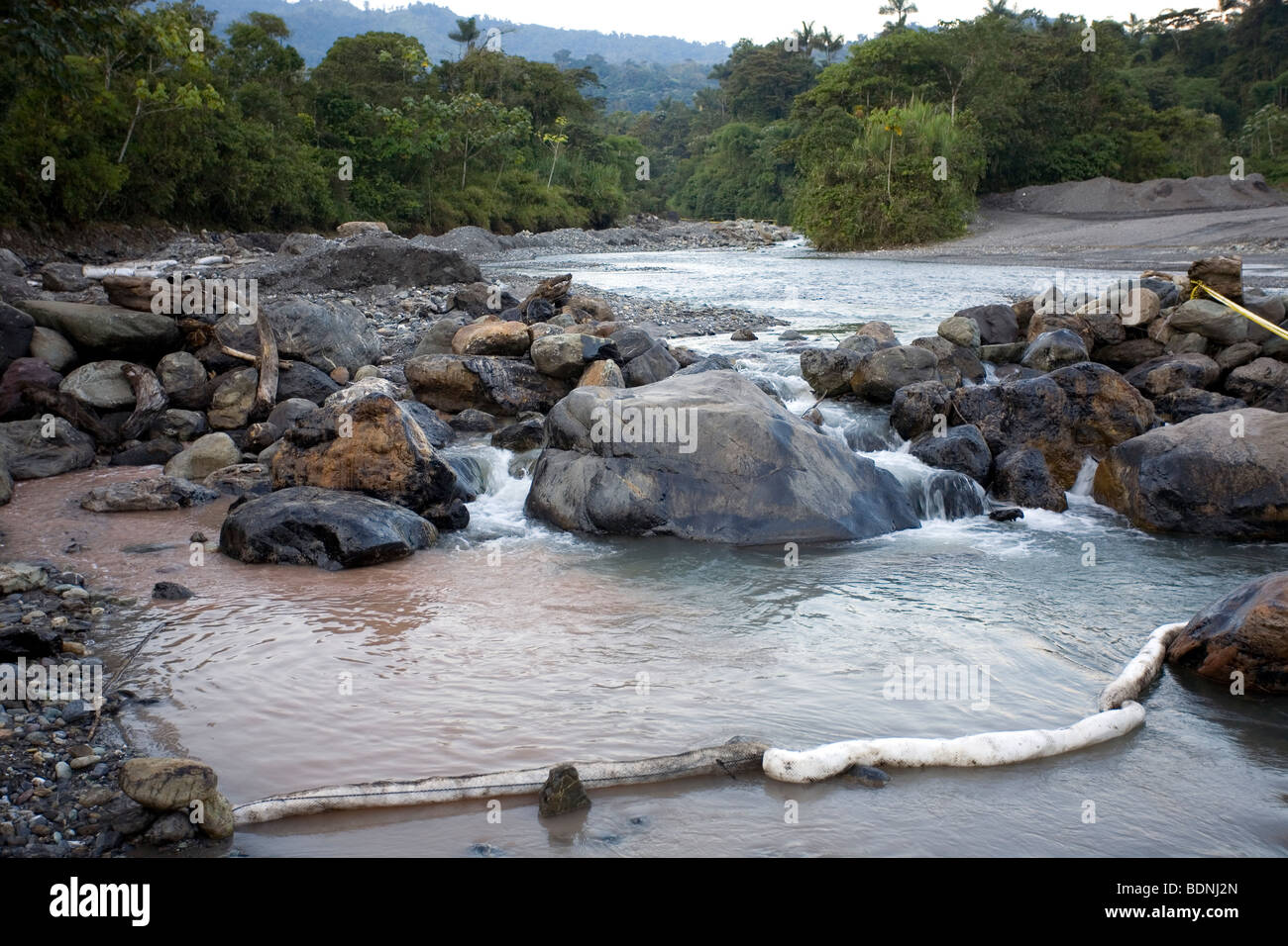 Boom assorbente i luoghi che si trovano di fronte un fiume amazzonico durante il processo di pulitura di una fuoriuscita di petrolio. Foto Stock