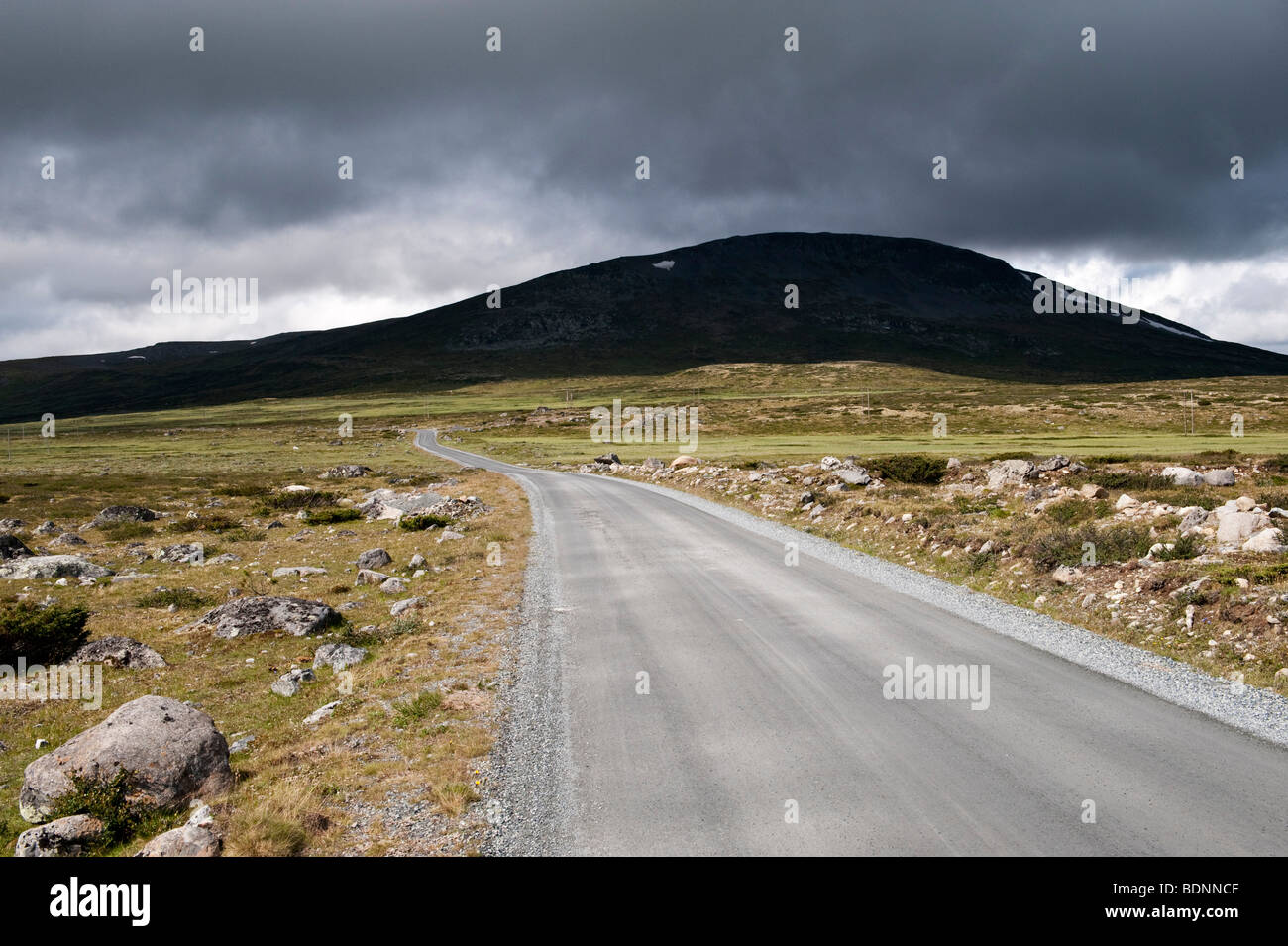 Una tempesta in avvicinamento su una strada solitaria alta tra le montagne sopra Lillehammer, Norvegia Foto Stock