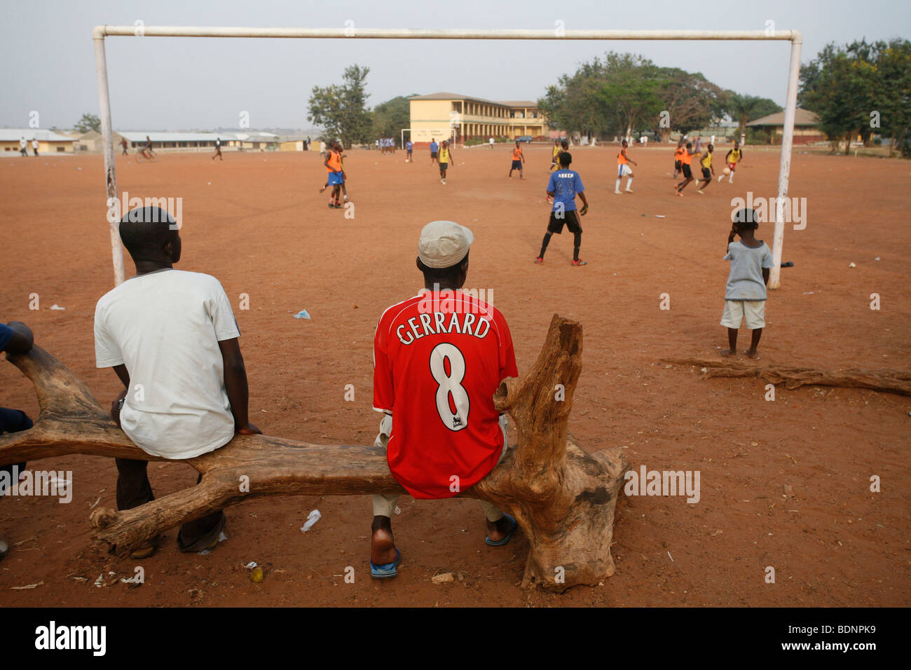 Uomo che indossa Liverpool shirt orologi pratica di gioco del calcio. Angoli di neonati Youth Football Academy . Kumasi. Il Ghana. Foto Stock