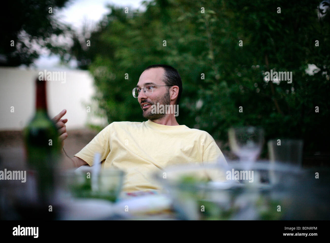 Uomo seduto al tavolo da pranzo all'aperto Foto Stock