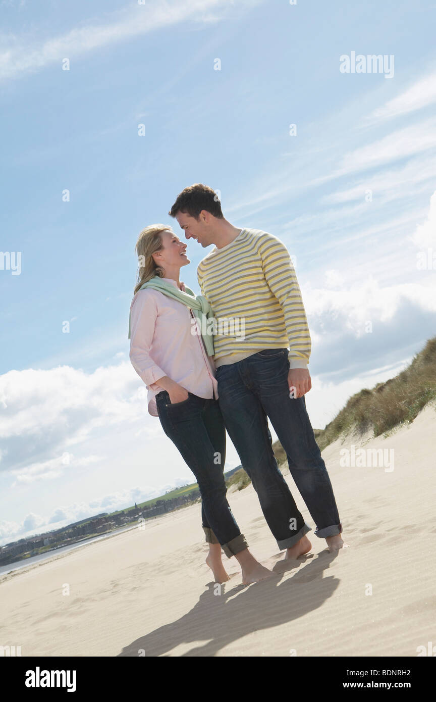 Matura in piedi faccia a faccia sulla spiaggia Foto Stock