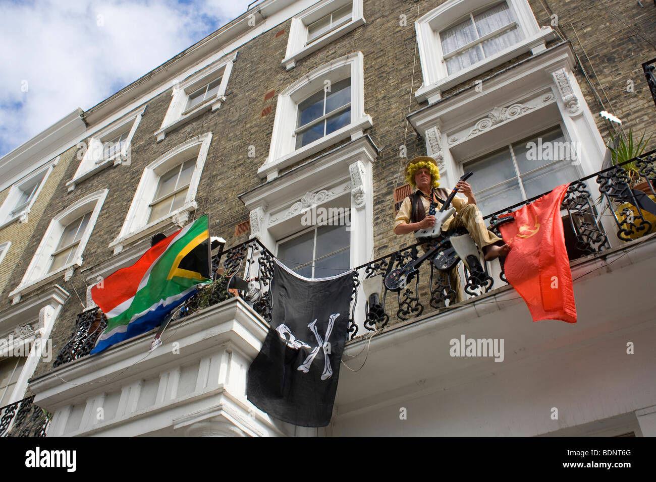 Musicista residente in London Notting Hill si affaccia dal suo balcone durante il carnevale di Notting Hill 2009 Foto Stock