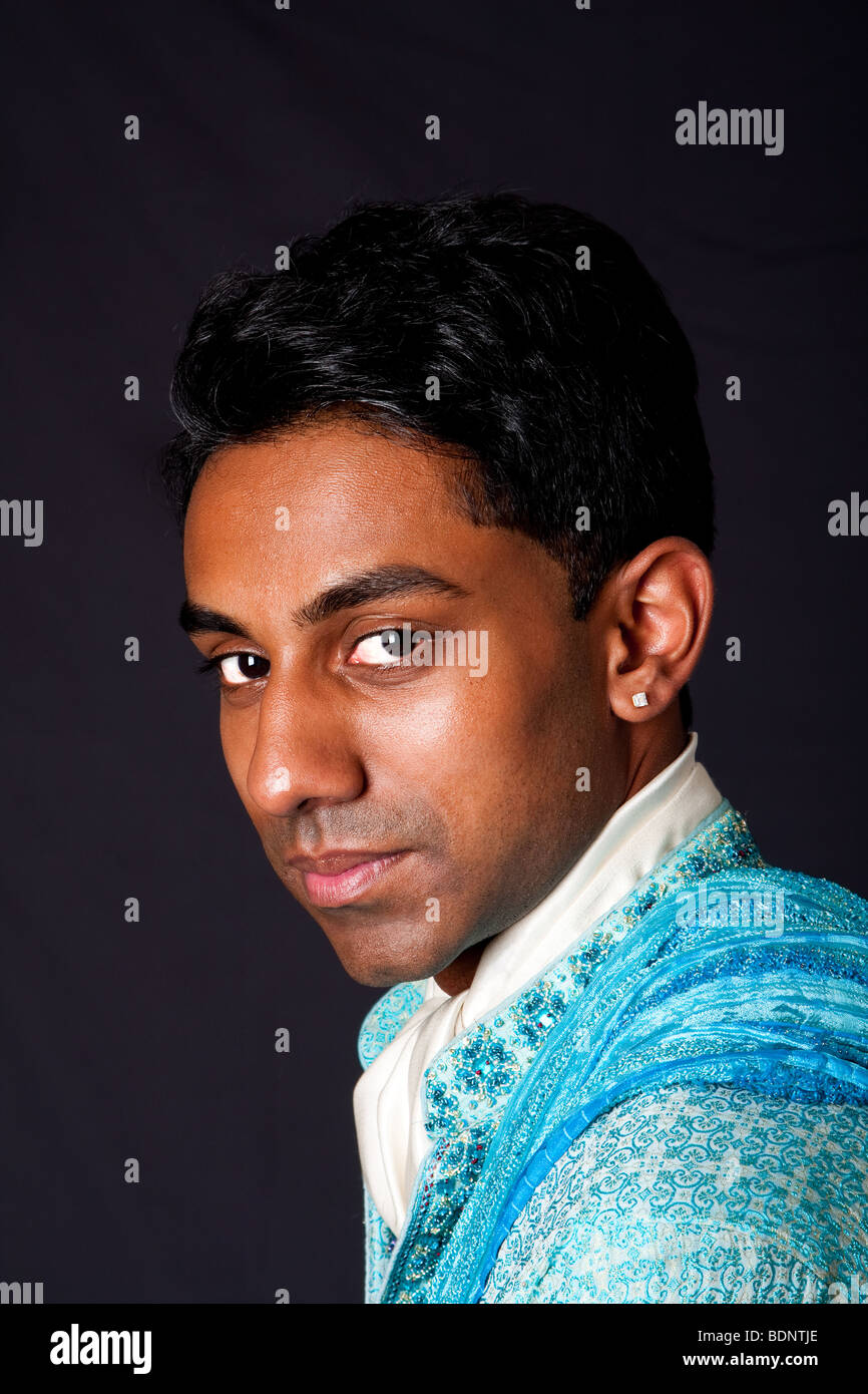 Bella faccia di un indiano Hindu giovane con earing indossare Dhoti blu. Ritratto di Desi bello maschio, isolata. Foto Stock