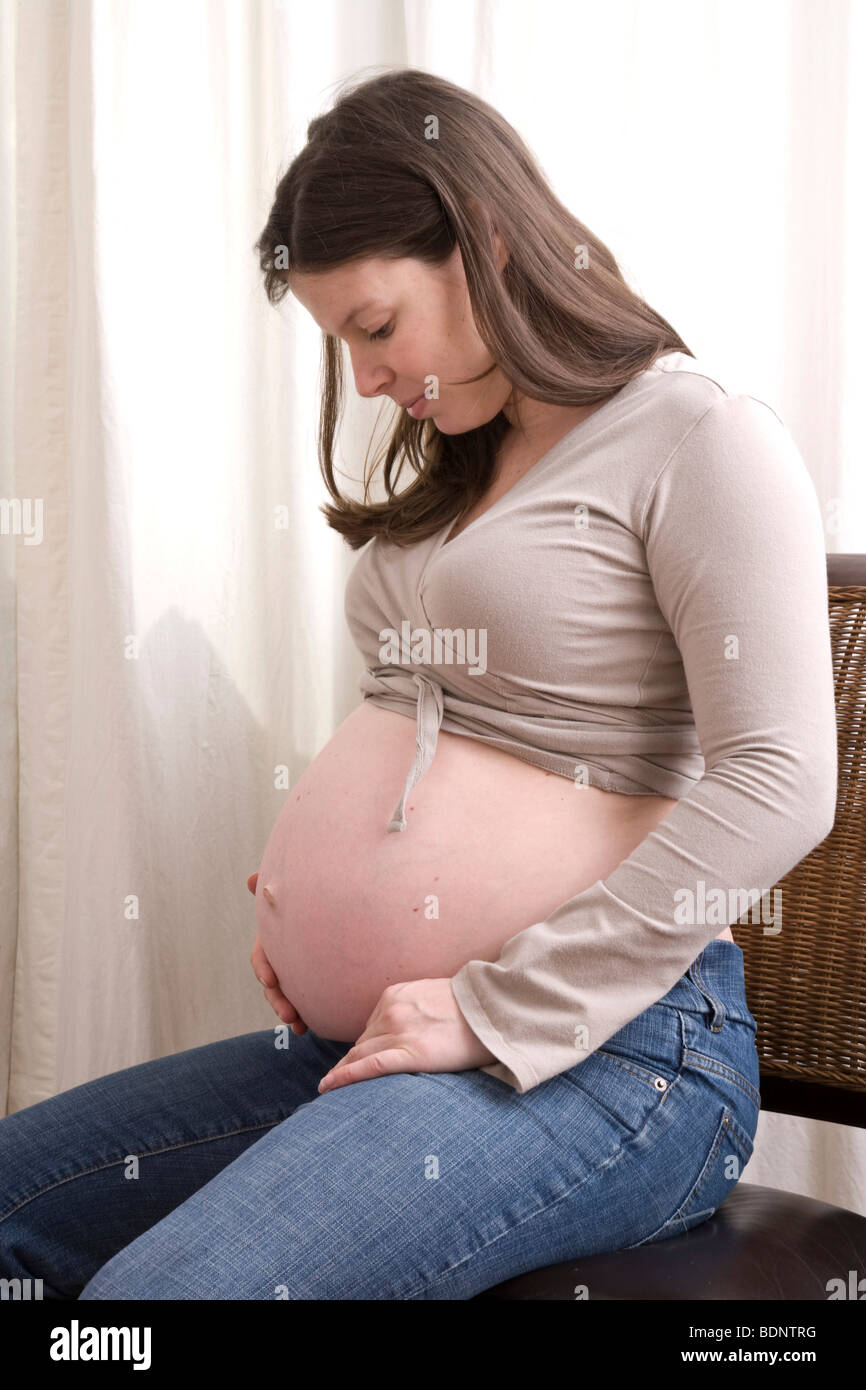 Donna incinta osservando il suo ventre Foto Stock