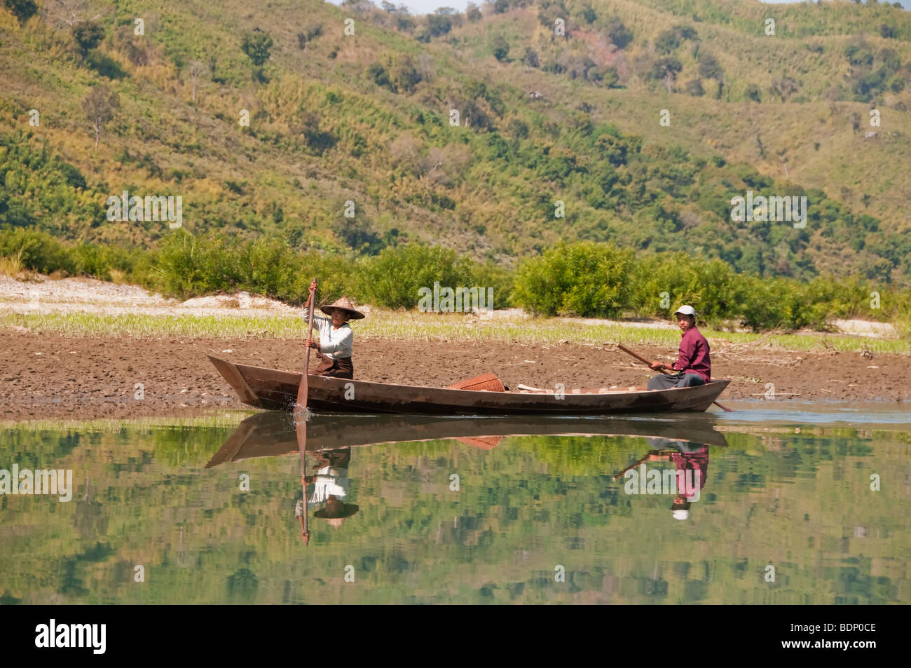 Tribù mento persone paddling loro piroga barca sul Le Mro fiume vicino a Mrauk U mento e villaggi, Rakhine unito, Myanmar, Burm Foto Stock
