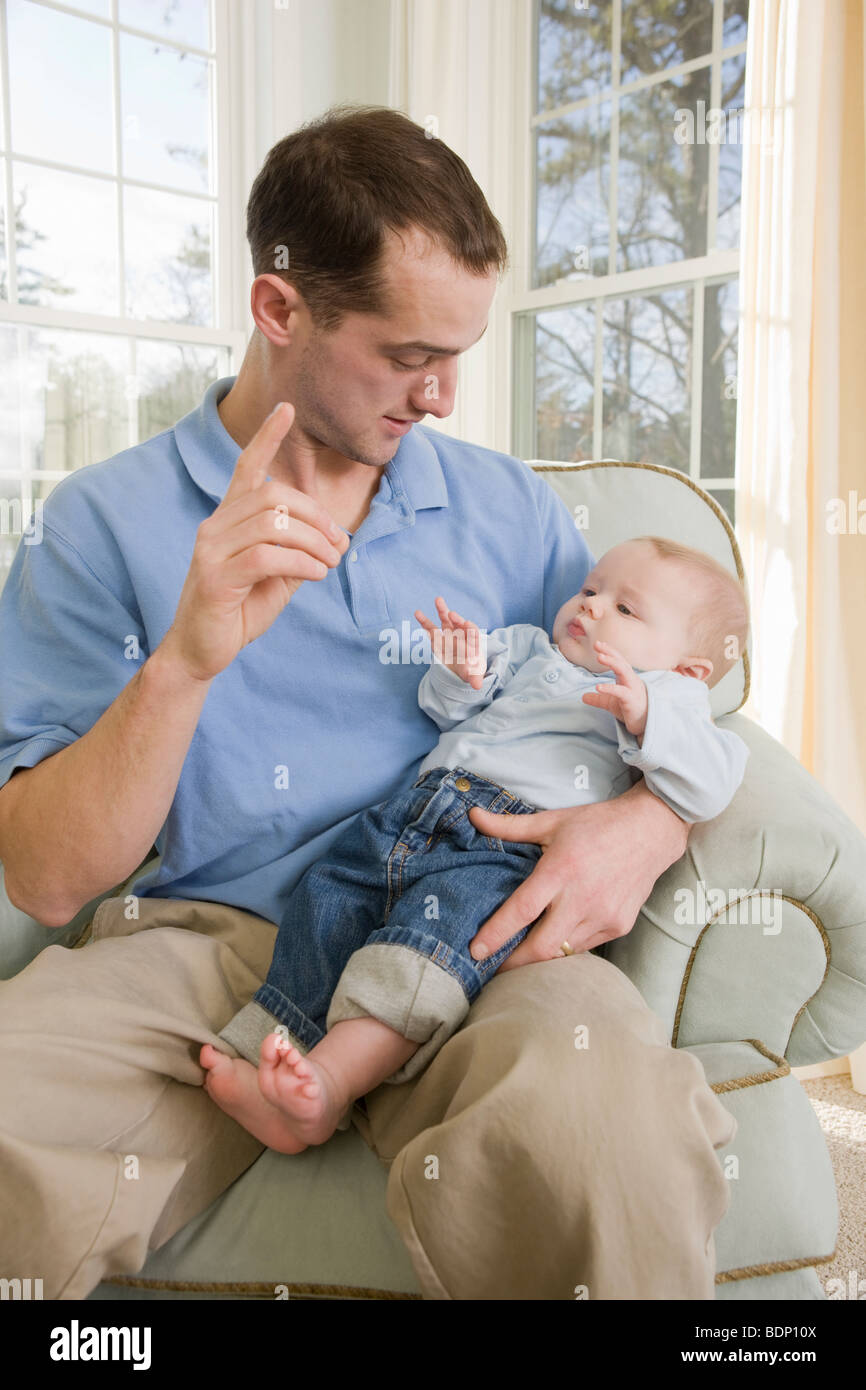 L'uomo firma la parola 'D' in American Sign Language durante la comunicazione con il suo figlio Foto Stock