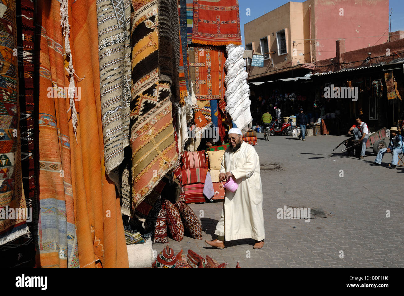 Uomo arabo musulmano marocchino o negoziante che indossa una Jellaba nel Bazaar dei tappeti, suk o mercato, Marrakech, Marocco Foto Stock