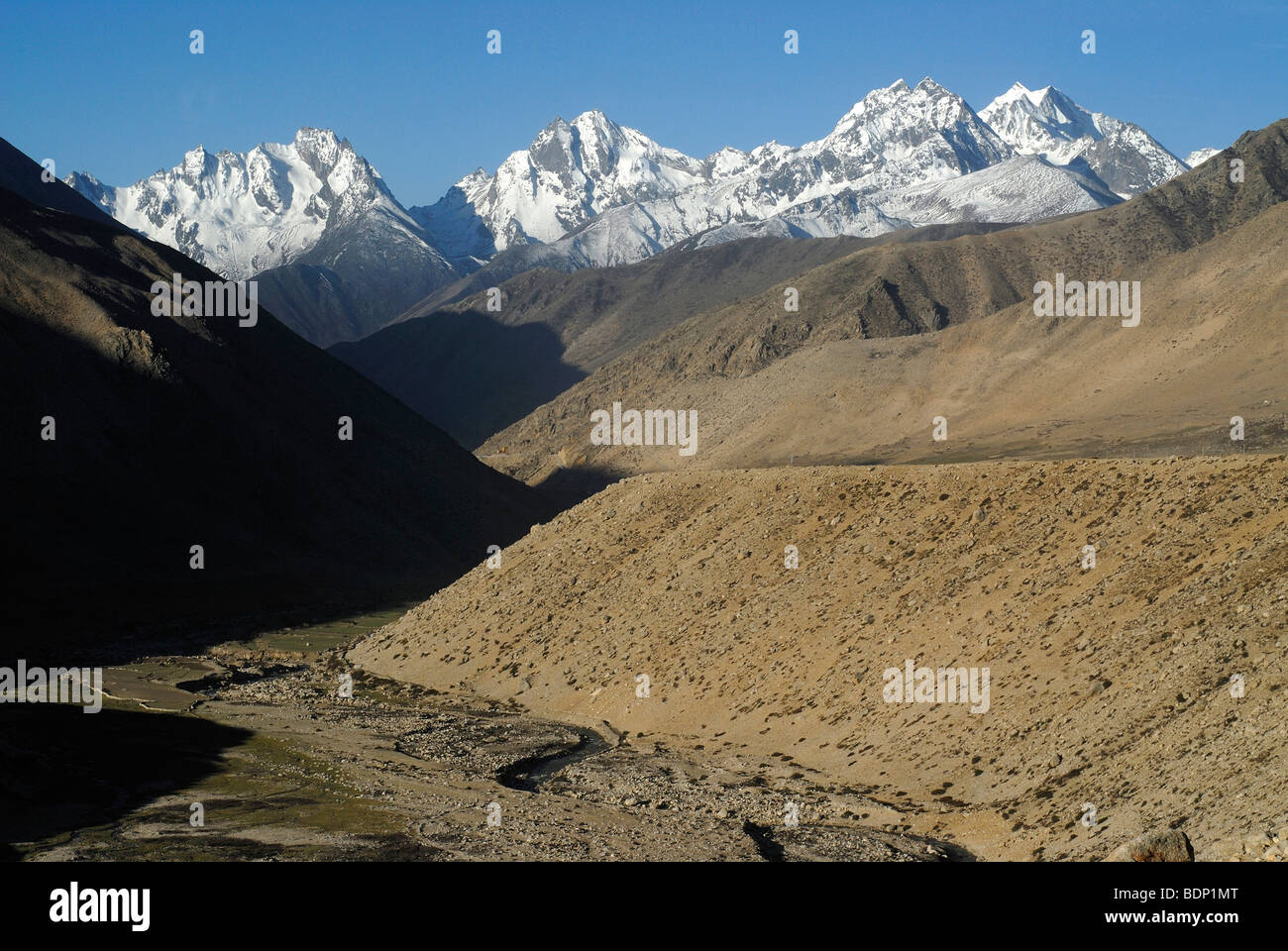 Coperte di neve cresta principale dell'Himalaya con strada di montagna e il fiume al sole del mattino nei pressi di Tarong-la Pass, Tingri, Nyalam, T Foto Stock