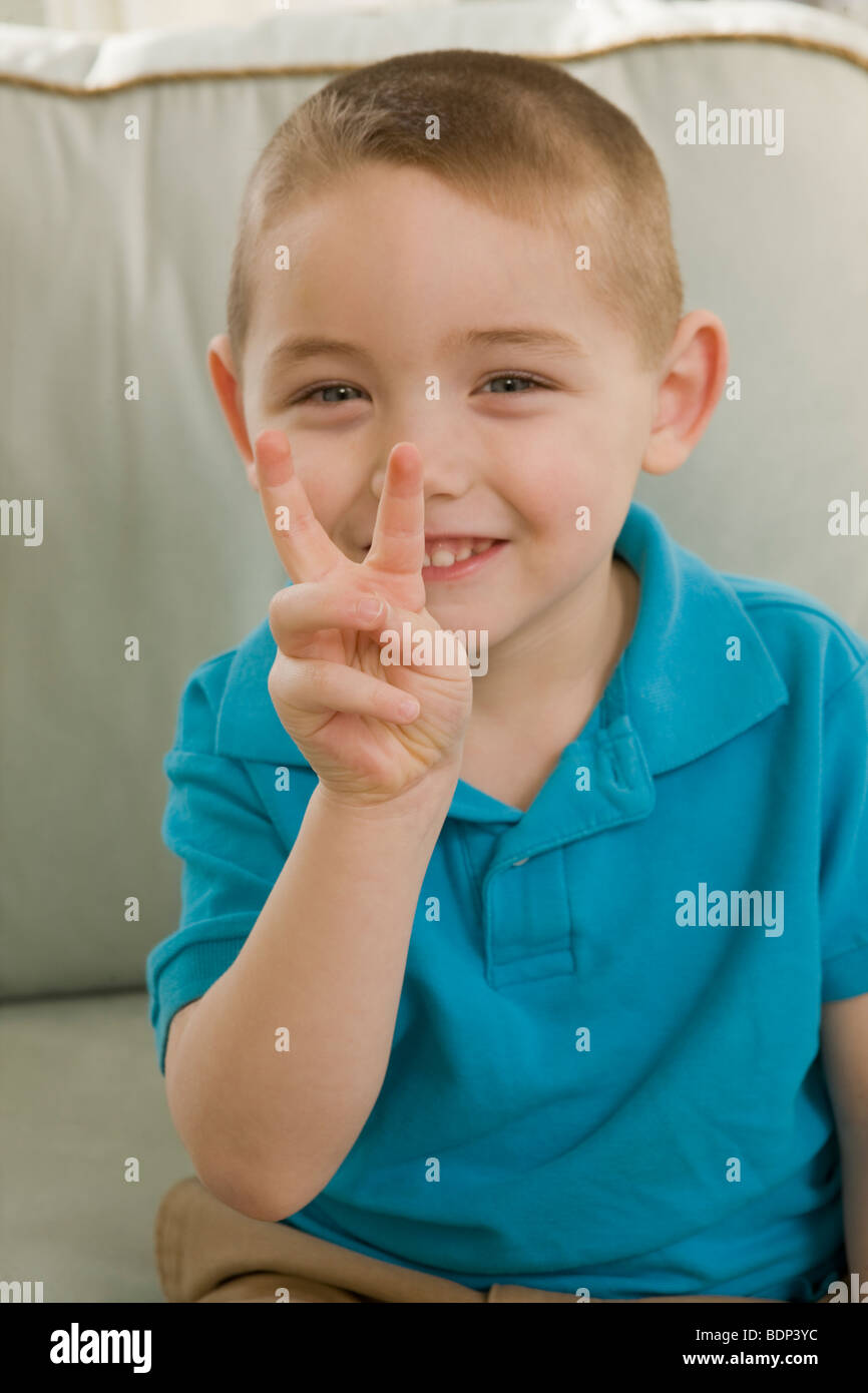 Ragazzo firma la lettera "V" in American Sign Language Foto Stock