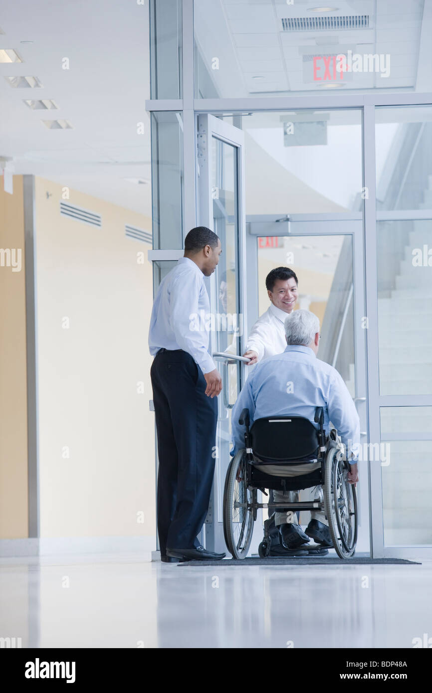 Tre professori universitari alla porta Foto Stock