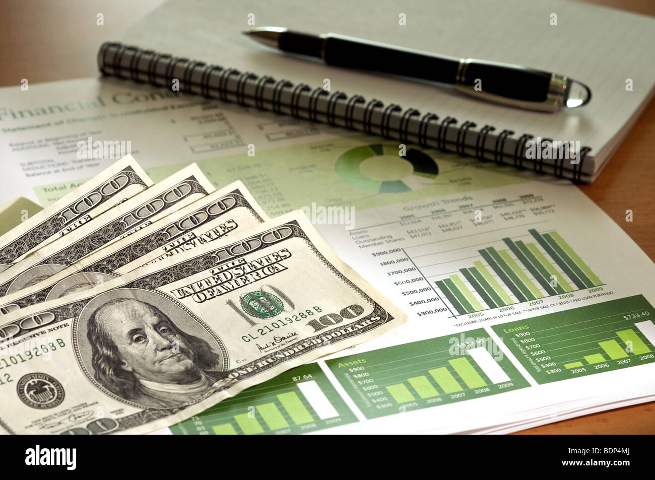 Cassa e report finanziari desktop shot con un evidenziare sulla moneta e i grafici a barre. Foto Stock