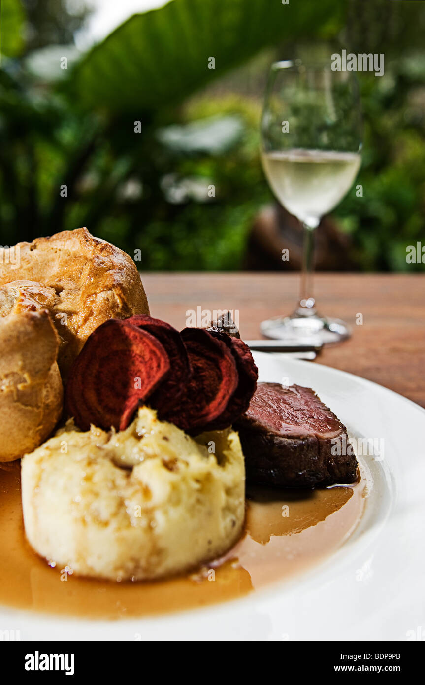 Un arrosto di manzo con purè di patate, Yorkshire pudding, barbabietole chip, con sugo di carne e un bicchiere di vino bianco. Foto Stock Un arrosto di manzo con purè di patate, Yorkshire pudding, barbabietole chip, con sugo di carne e un bicchiere di vino bianco. Foto Stock