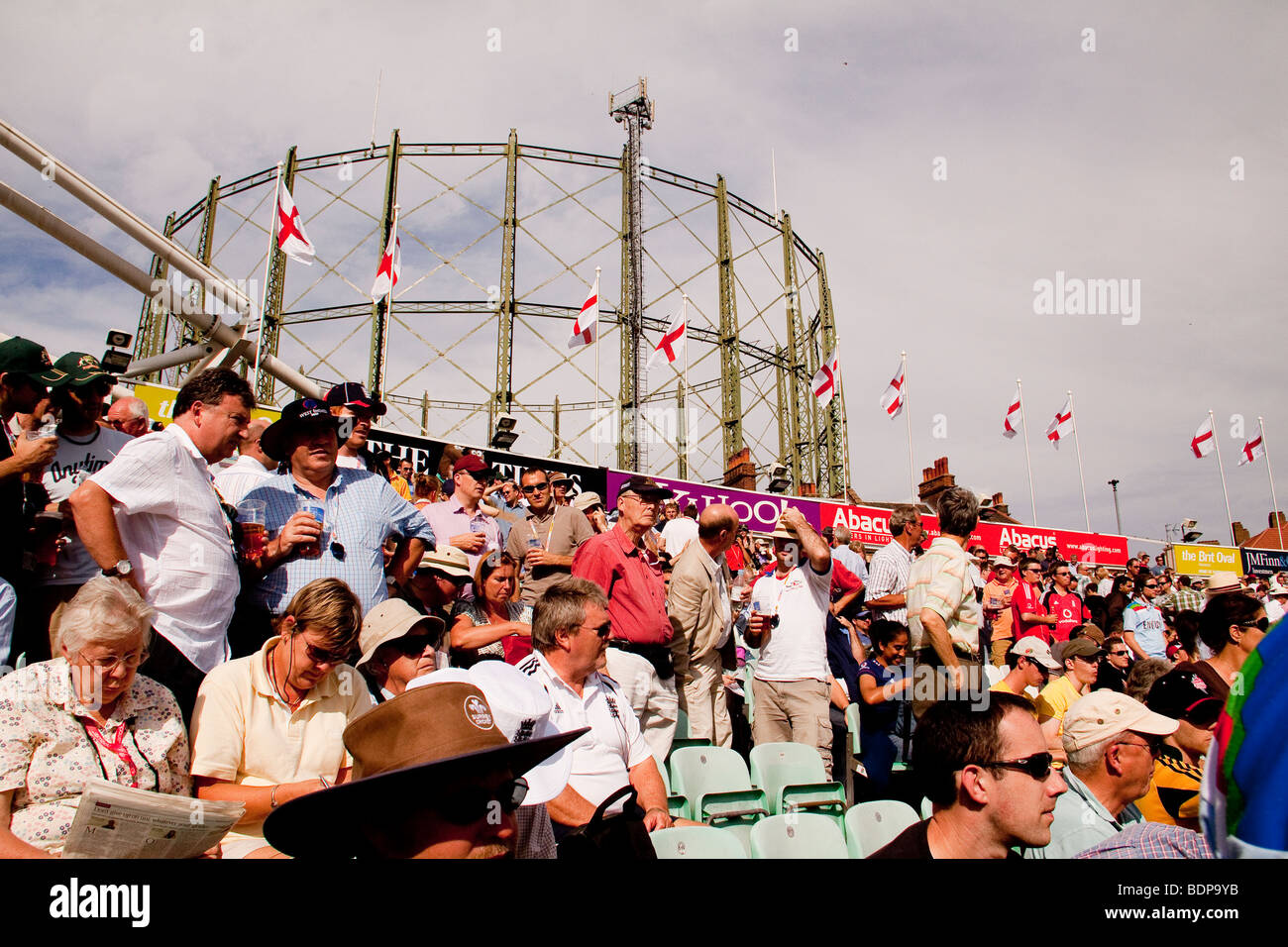 La folla guarda la partita di cricket di fronte ad un contenitore di gas, London, Regno Unito l'Ovale Foto Stock