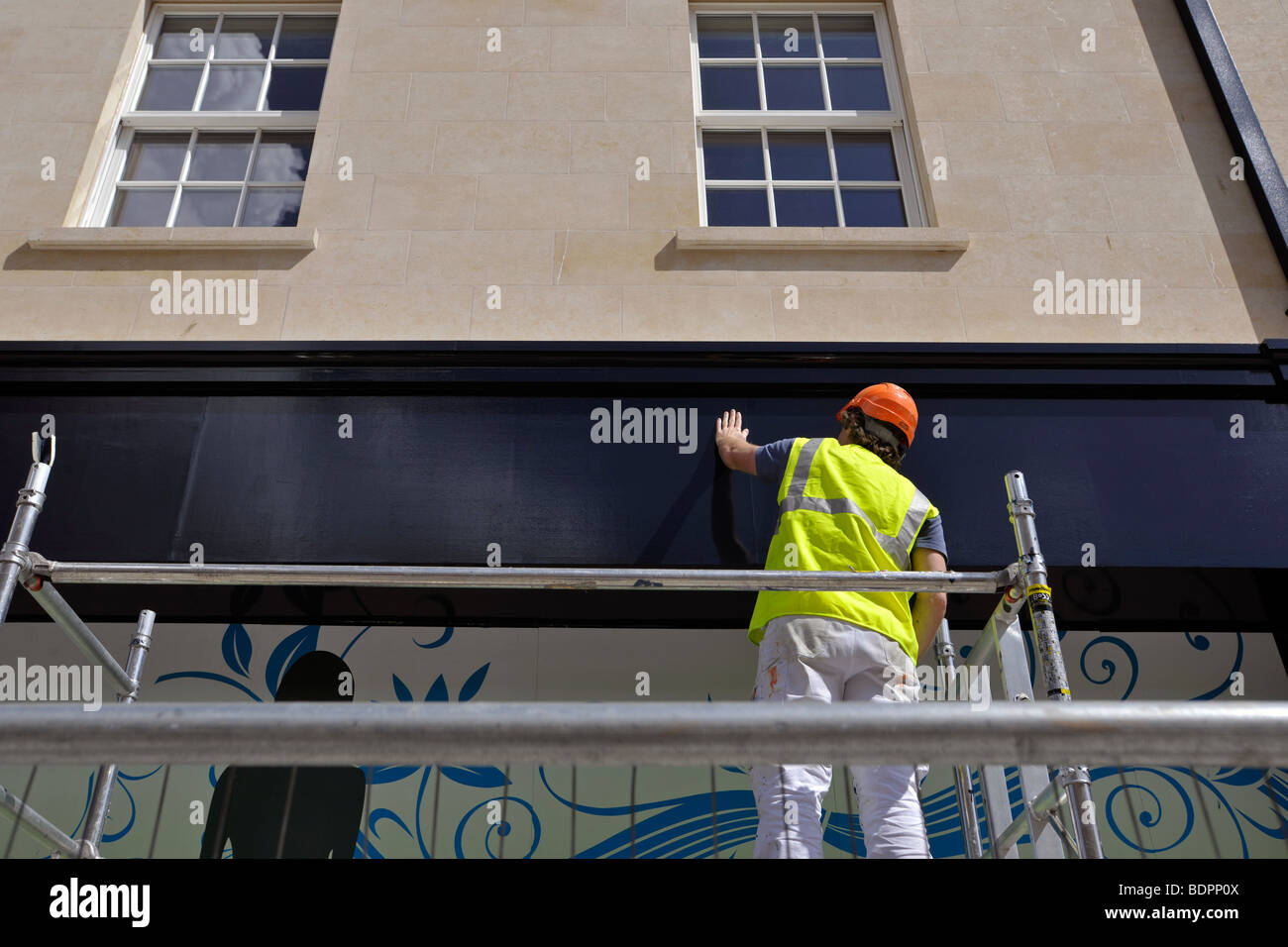 Workman lavorando sul negozio di fronte Foto Stock