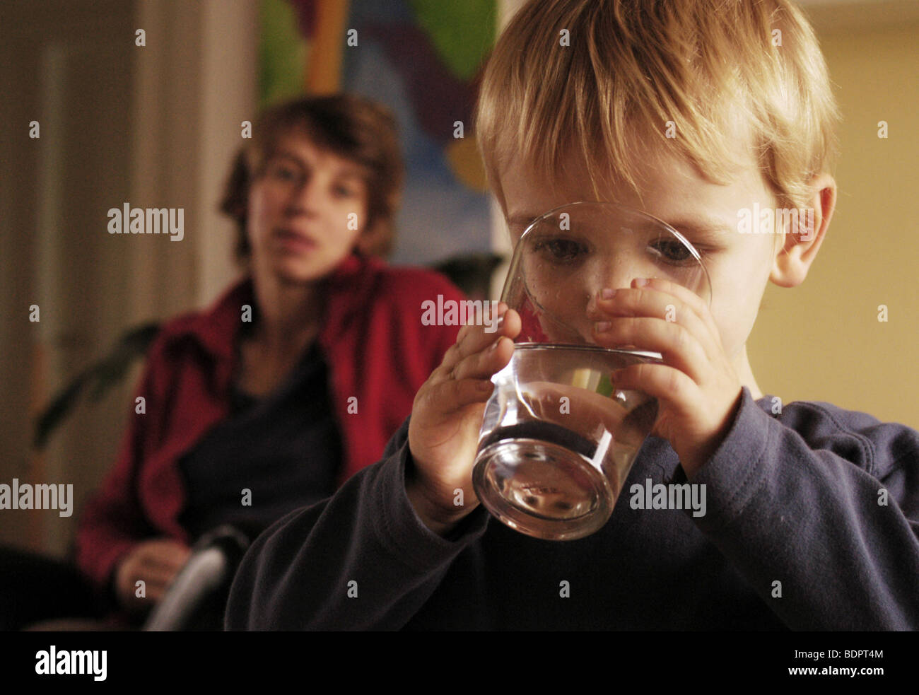 Ragazzo con pensieroso madre in background Foto Stock