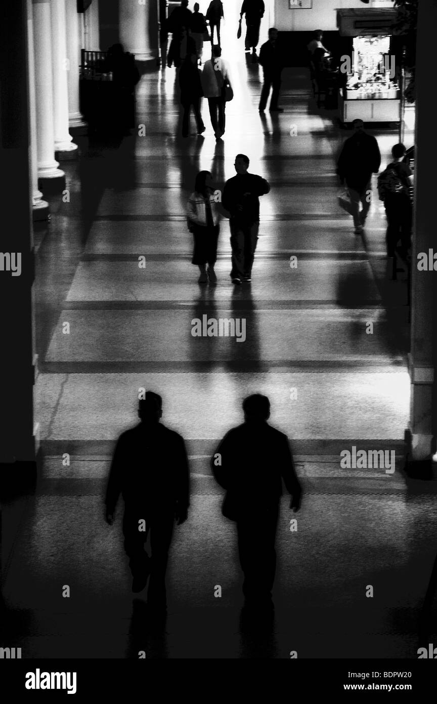 Le figure a camminare in una stazione ferroviaria Foto Stock