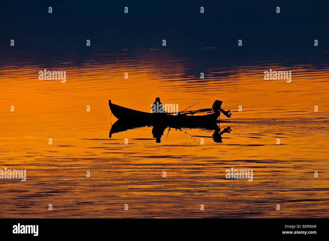 Il pescatore in barca sul fiume Torne in corrispondenza di post-incandescenza, Lapponia, Svezia Foto Stock