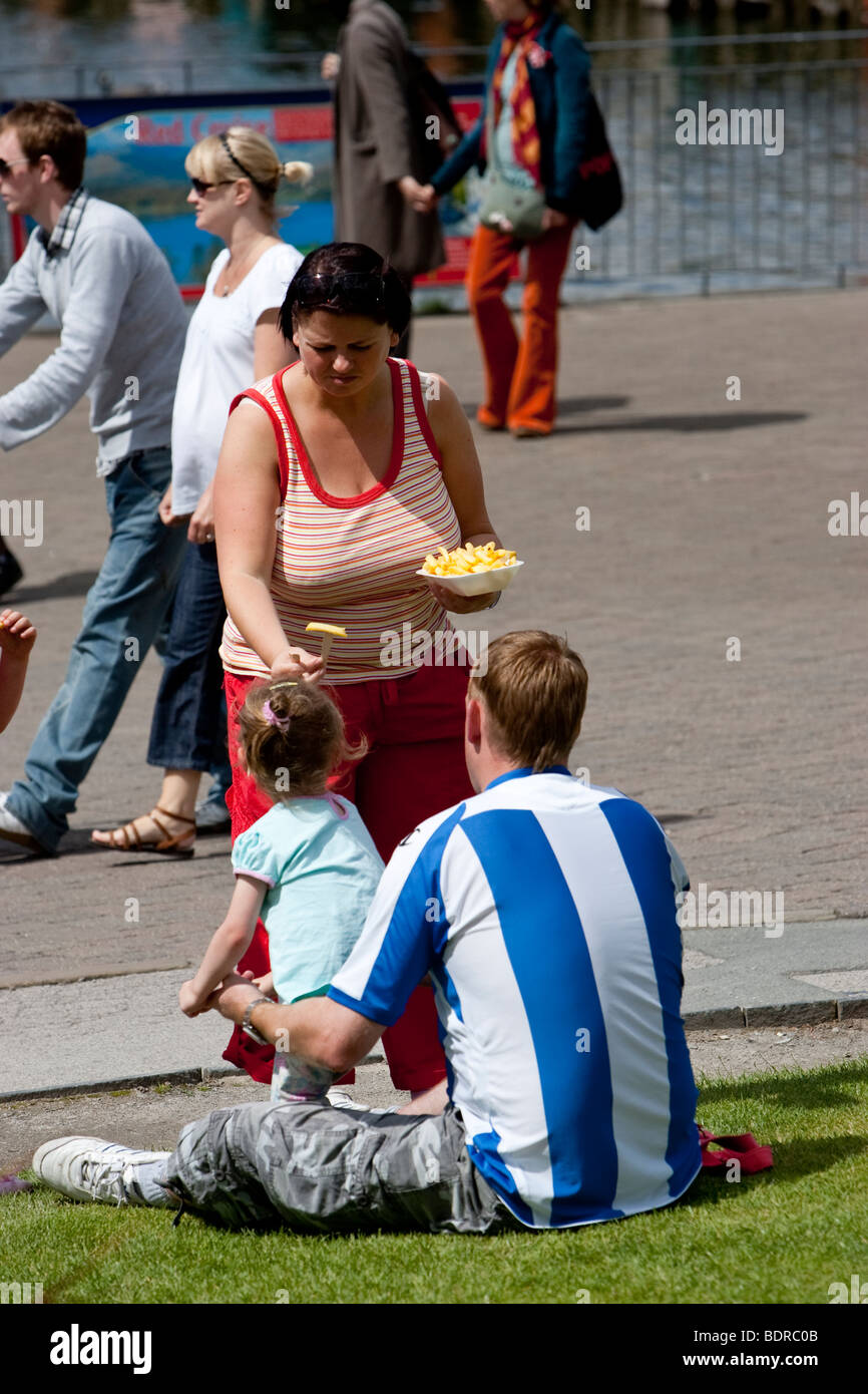 La giornata della famiglia in Bowness on Windermere & mangiare pasti da asporto pesce e patatine fritte Foto Stock