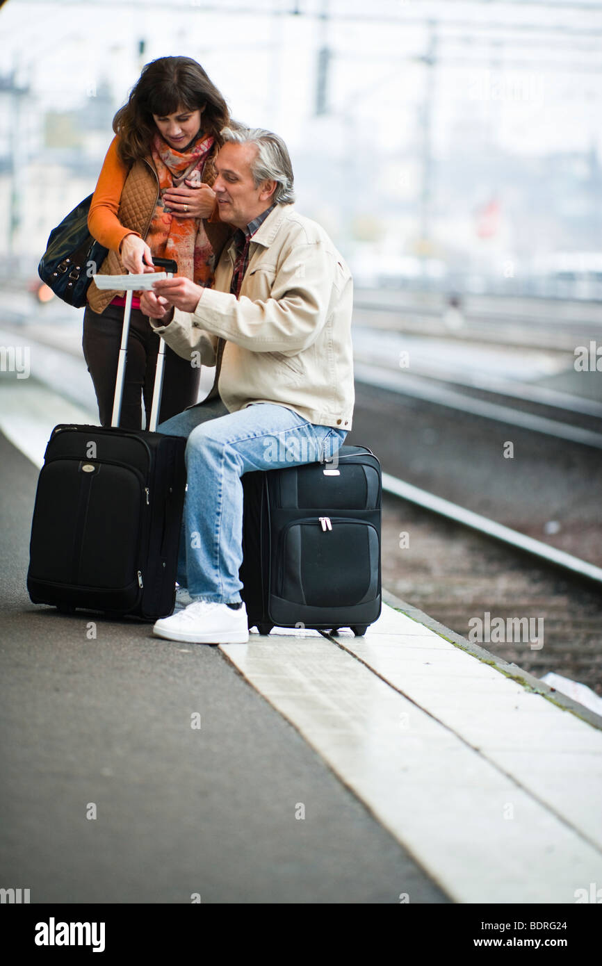 Una coppia in attesa di un treno Foto Stock