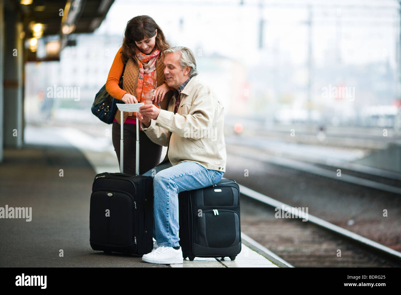 Una coppia in attesa di un treno Foto Stock
