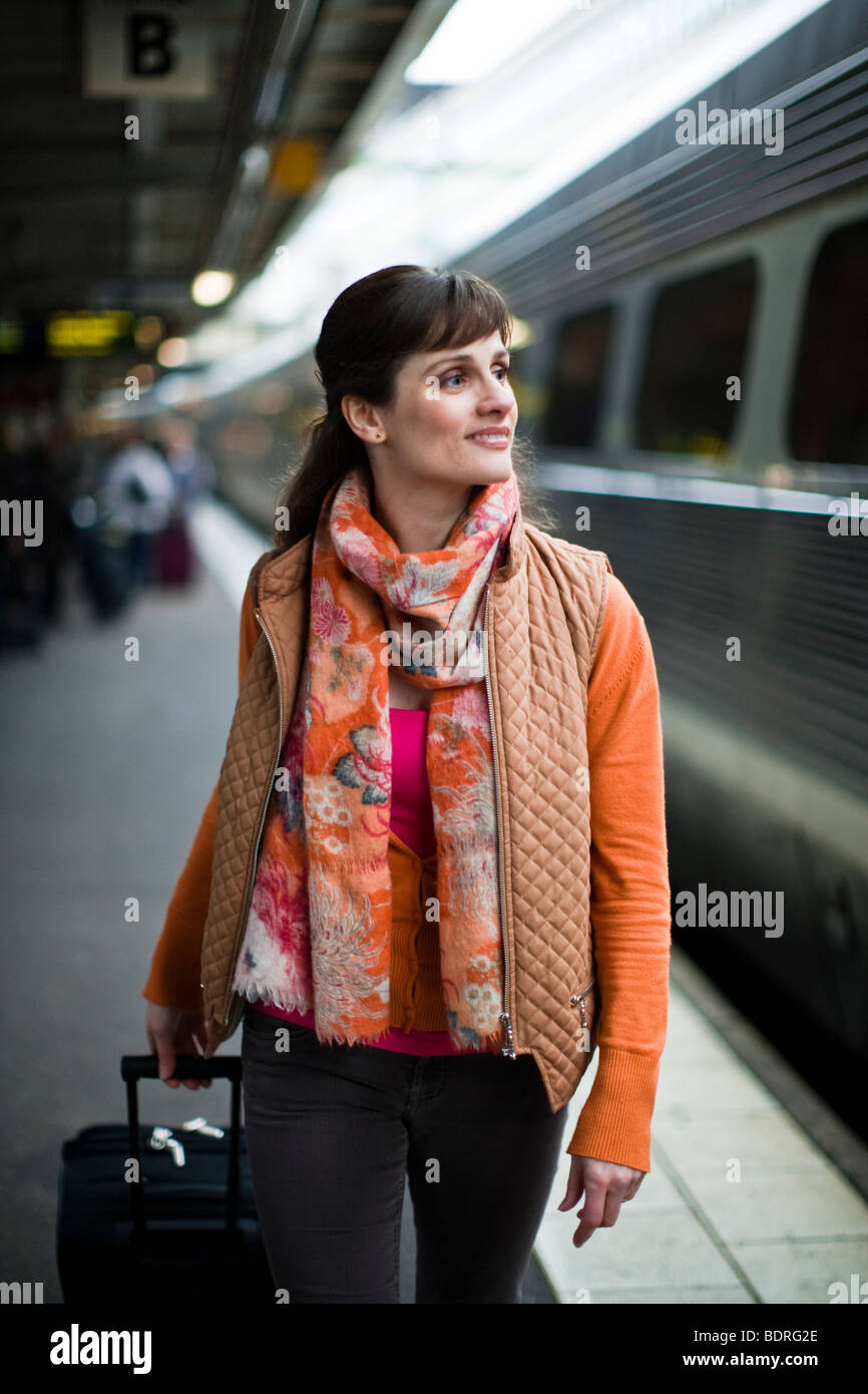 Una donna in una stazione ferroviaria Foto Stock